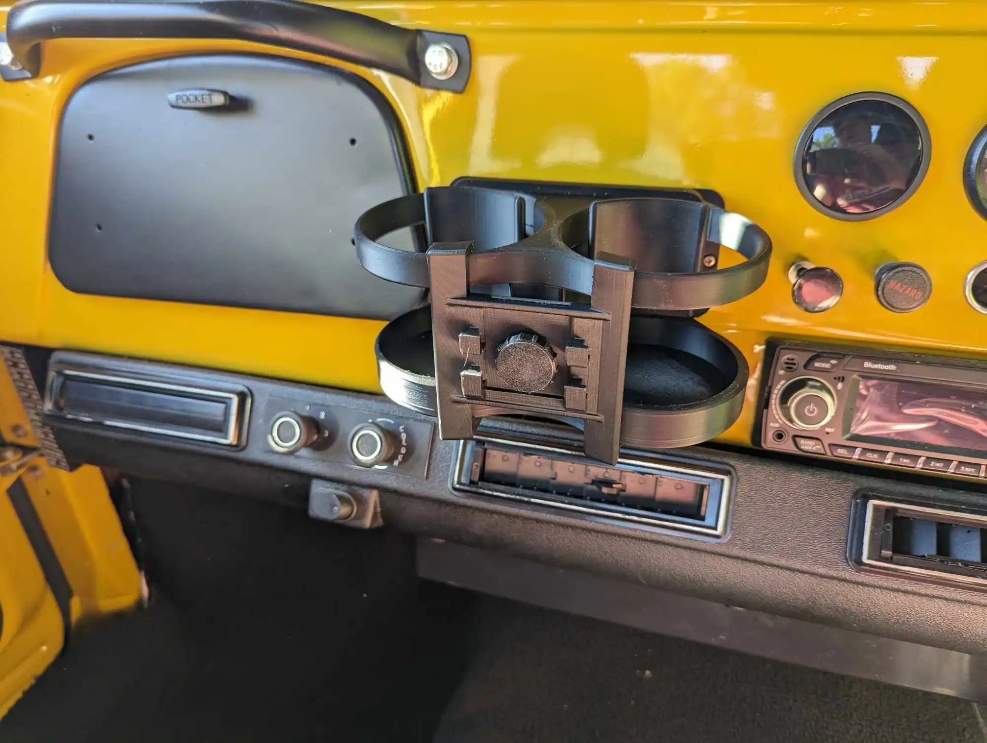 Cup holder mounted to the dashboard of a classic Volkswagen Beetle.
