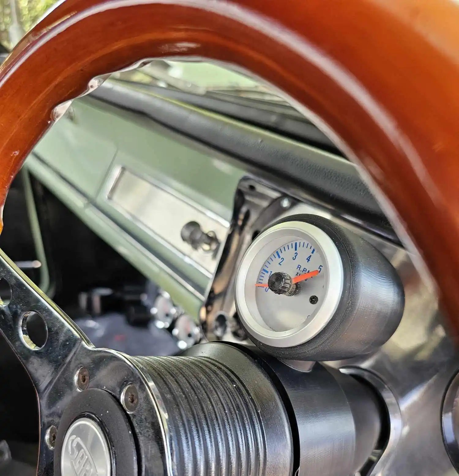 Automotive gauge mounted in what appears to be an engine compartment.